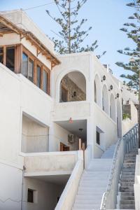 a white house with stairs leading up to it at Almira Inn in Ios Chora