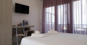 a bedroom with a bed with two towels on it at Calua SeaView Rooms in Kriopigi