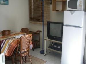een keuken met een tafel, een koelkast en een televisie bij Appartement Saint-Cyprien, 1 pièce, 4 personnes - FR-1-225D-152 in Saint Cyprien Plage