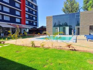 a building with a swimming pool in front of a building at Muthu Warwick Mount Kenya Hotel, Nanyuki in Nanyuki