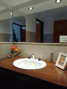 - Baño con lavabo y espejo en Departamento duplex en Villa General Belgrano