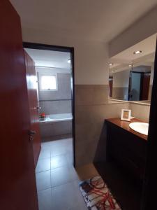 y baño con lavabo y espejo. en Departamento duplex en Villa General Belgrano
