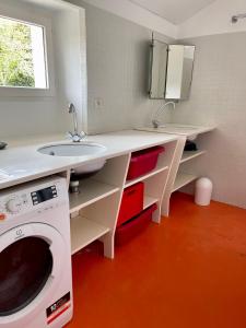 ein Badezimmer mit einem Waschbecken und einer Waschmaschine in der Unterkunft Maison de charme entre terre et mer, proche plages in Névez