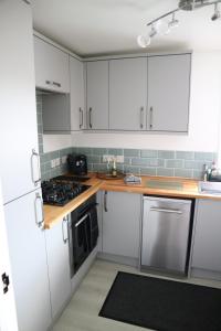 a kitchen with white cabinets and a stove top oven at 12 Ivy Cottage in St Ives