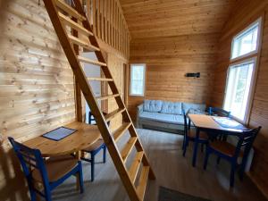 una escalera en una cabaña de madera con mesa y sillas en Santtioranta Camping, en Uusikaupunki