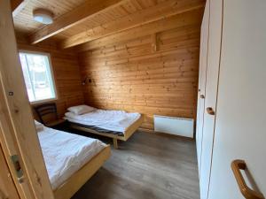 a room with two beds in a wooden cabin at Santtioranta Camping in Uusikaupunki