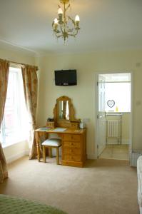 1 dormitorio con tocador, espejo y escritorio en Pear Tree House B&B, en Pickering