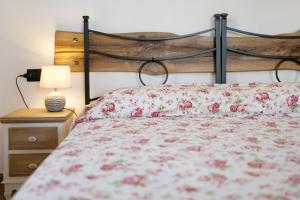 - une chambre avec un lit orné de fleurs roses dans l'établissement Timo, à Pompeiana