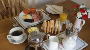 a table with a plate of breakfast food and a cup of coffee at Pear Tree House B&B in Pickering