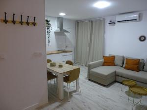 salon z białą kanapą i stołem w obiekcie Casasjerezanas Loft Aitana w mieście Jerez de la Frontera