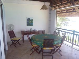 a dining room with a table and chairs on a balcony at Haute Crécerelle in Pereybere