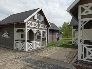 a house with a gambrel roof and white trim at Domkoland in Dziwnówek