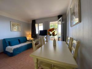 ein Wohnzimmer mit einem Tisch und einem blauen Sofa in der Unterkunft Appartement Les Issambres, 1 pièce, 4 personnes - FR-1-226-84 in Les Issambres