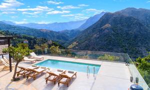 Villa Barozziana Private Heated Pool & Jacuzzi في مدينة ريثيمنو: مسبح مع كراسي وإطلالة على الجبال