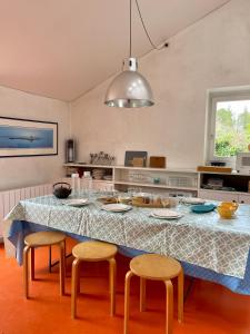 a kitchen with a table with four chairs and a blue table cloth at Maison de charme entre terre et mer, proche plages in Névez