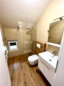 uma casa de banho com um WC branco e um lavatório. em Daman Villa em Bihać