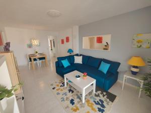 een woonkamer met een blauwe bank en een tafel bij Panorama Apartment with Sea Views in Torremolinos