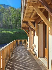 un porche de madera de una casa con techo de madera en Auberge du Glandon, en Saint-Colomban-des-Villards