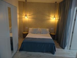 sypialnia z łóżkiem z dwoma światłami na ścianie w obiekcie Casasjerezanas Loft Aitana w mieście Jerez de la Frontera