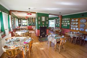 a restaurant with tables and chairs and a fireplace at Teac Campbell Guesthouse in Bunbeg