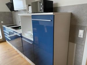 a blue refrigerator with a microwave on top of it at 2 Raum Apartment mit Terrasse, hell und stilvoll in Borna