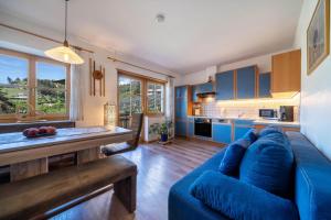 uma sala de estar com um sofá azul e uma cozinha em Feldhof Apartment Golden Delicious em Caines