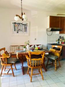 uma cozinha com uma mesa de madeira e cadeiras num quarto em Beautiful Apartment with balcony em Pula