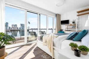 a bedroom with a bed and a large window at Schwimmendes Haus Aloha in Olpenitz