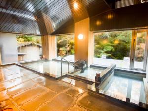 LiVEMAX RESORT Shizuoka Amagiyugashima في إيزو: حمام سباحة مع قطة تجلس فوقه