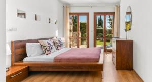 ein Schlafzimmer mit einem Holzbett und einem Fenster in der Unterkunft Pool side ground floor apartment BF02 - Theseus Village, Aphrodite Hills Resort in Kouklia
