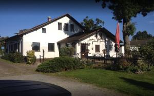 ein weißes Haus mit einer Flagge davor in der Unterkunft Pension Alte Schmiede in Greifswald