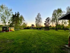 a large grassy field with a playground in a park at Brīvdienu māja- Silavas in Rucava