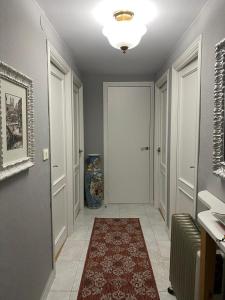 un corridoio con una porta bianca e un tappeto rosso di Casa Taboada Ribeira Sacra a Vilelos