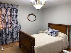 a bedroom with a bed and a mirror and a window at Casa Taboada Ribeira Sacra in Vilelos