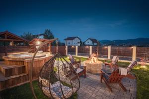 a patio with a fire pit and chairs and a fire hydrant at Roots Villa Redwood in Braşov