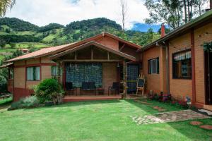a house with a patio and a yard at Pousada Vitoria in Gonçalves