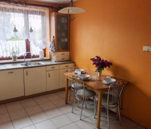 cocina con mesa con sillas y fregadero en Feels Like Home Metro Zacisze en Varsovia