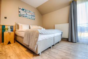 a bedroom with a bed and a large window at Apartamenty Bursztynowa17 in Niechorze