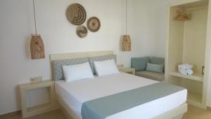ein Schlafzimmer mit einem großen Bett und einem Stuhl in der Unterkunft Maria's Rooms & Studios in Agia Anna