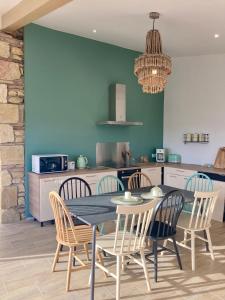 une salle à manger avec une table et des chaises dans une cuisine dans l'établissement Gîte et lodges du Hitton, à Biran