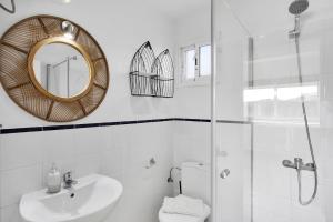 un bagno bianco con lavandino e specchio di Apartamentos Marinera I y II a Cotillo Altre 34 foto