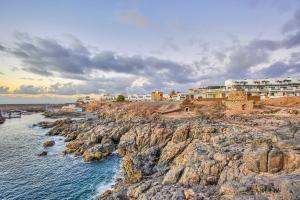 un gruppo di edifici sulla cima di una costa rocciosa di Apartamentos Marinera I y II a Cotillo