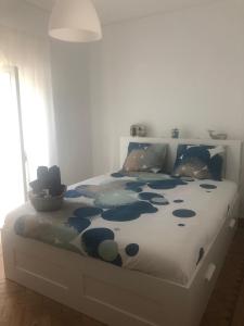 a bedroom with a bed with a blue and white comforter at Lagos Haven Guesthouse in Lagos