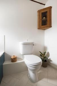 a bathroom with a white toilet and a wooden cabinet at Character cottage in the heart of Uplyme. in Uplyme