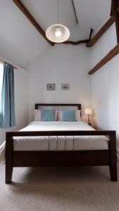 ein Schlafzimmer mit einem großen Bett mit blauen Kissen in der Unterkunft Character cottage in the heart of Uplyme. in Uplyme