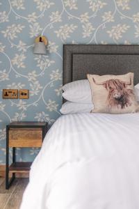 a bedroom with a bed with a dog pillow at The Blind Bull in Little Hucklow