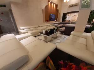 a living room with white couches and a couch at Amman Ambiance Hotel  in Amman