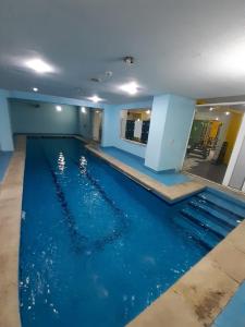 a swimming pool with blue water in a building at Amman Ambiance Hotel  in Amman