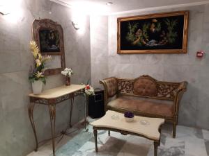 a room with a bench and a painting on the wall at Amman Ambiance Hotel  in Amman