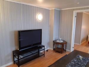 ein Wohnzimmer mit einem großen Flachbild-TV in der Unterkunft Fjord side apartment in Røyrvik
